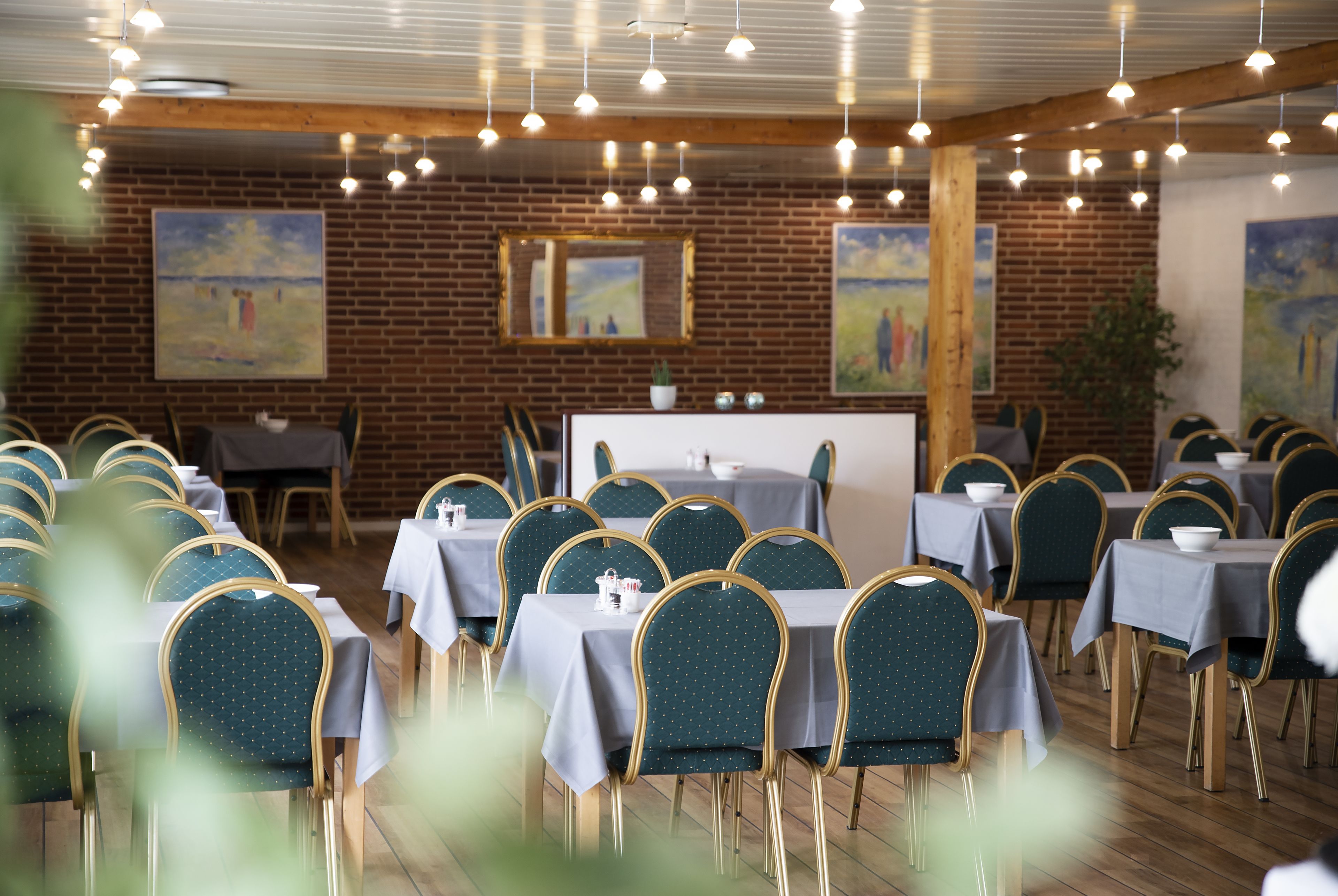 Un comedor con mesas y sillas dispuestas para atender a los comensales.