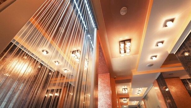 A modern interior with a water feature, recessed lighting, and a hallway leading to a door. - Hotel Almira (Samara)