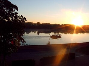 Un lago tranquilo con un barco al atardecer.