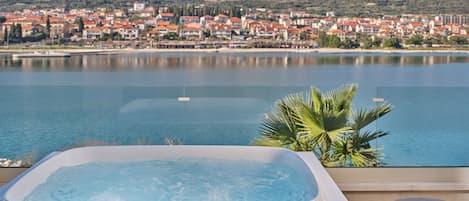Un jacuzzi con vistas a un pueblo costero y montañas.