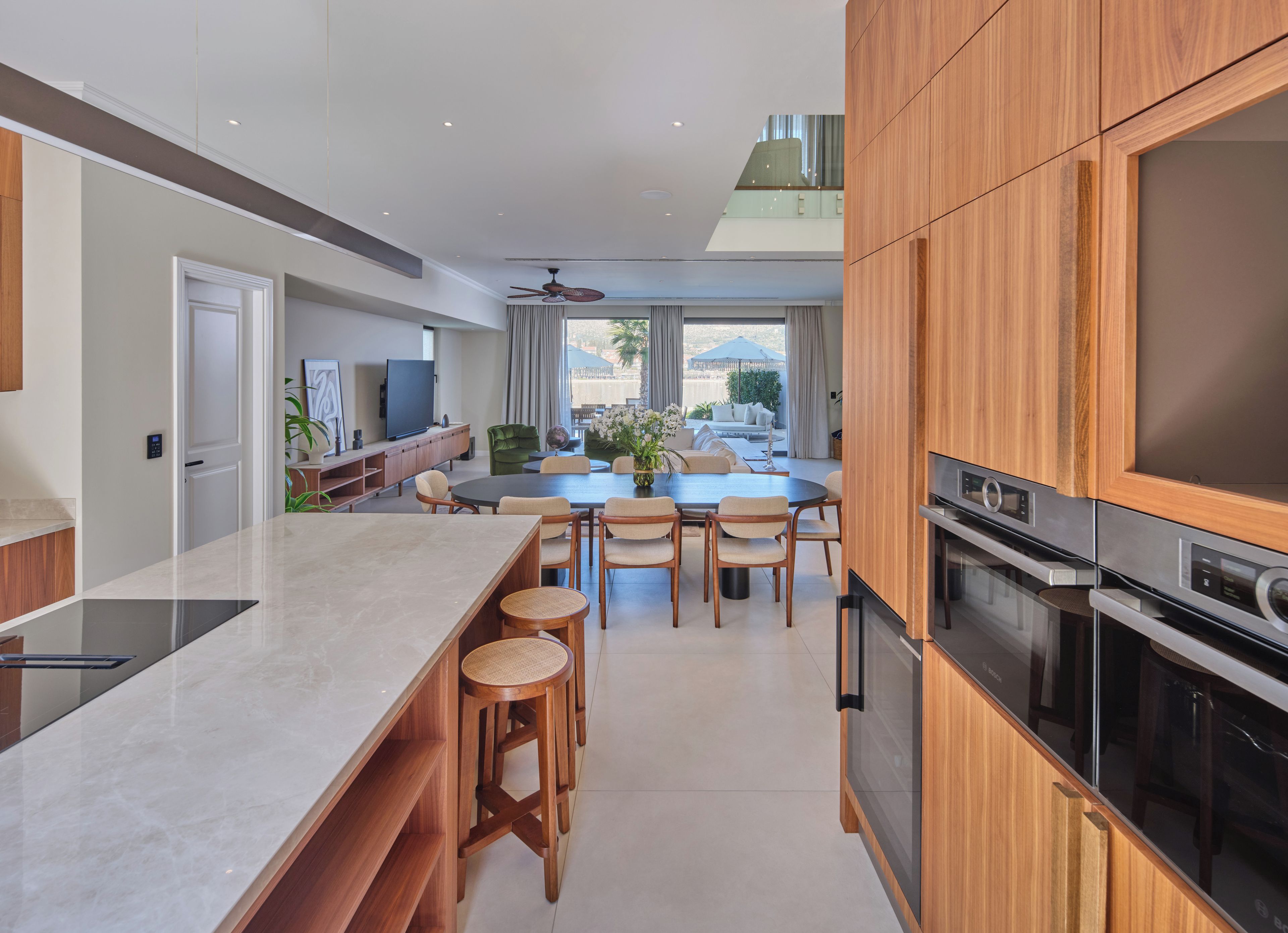 Una cocina moderna con una isla central, armarios de madera y electrodomésticos integrados.