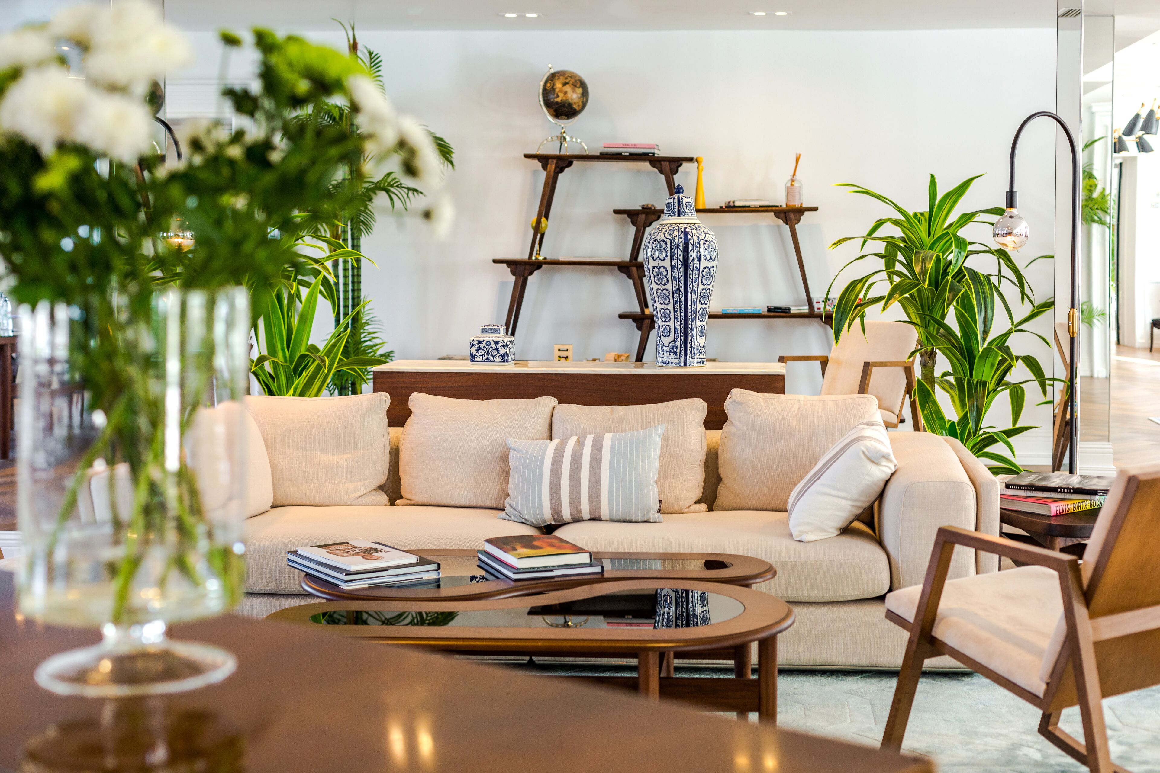 A modern living room with a beige sofa, a coffee table, and a bookshelf.
