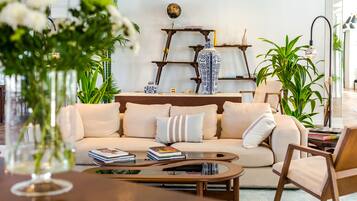 Una sala de estar moderna con un sofá color beige, una mesa de centro y una estantería.