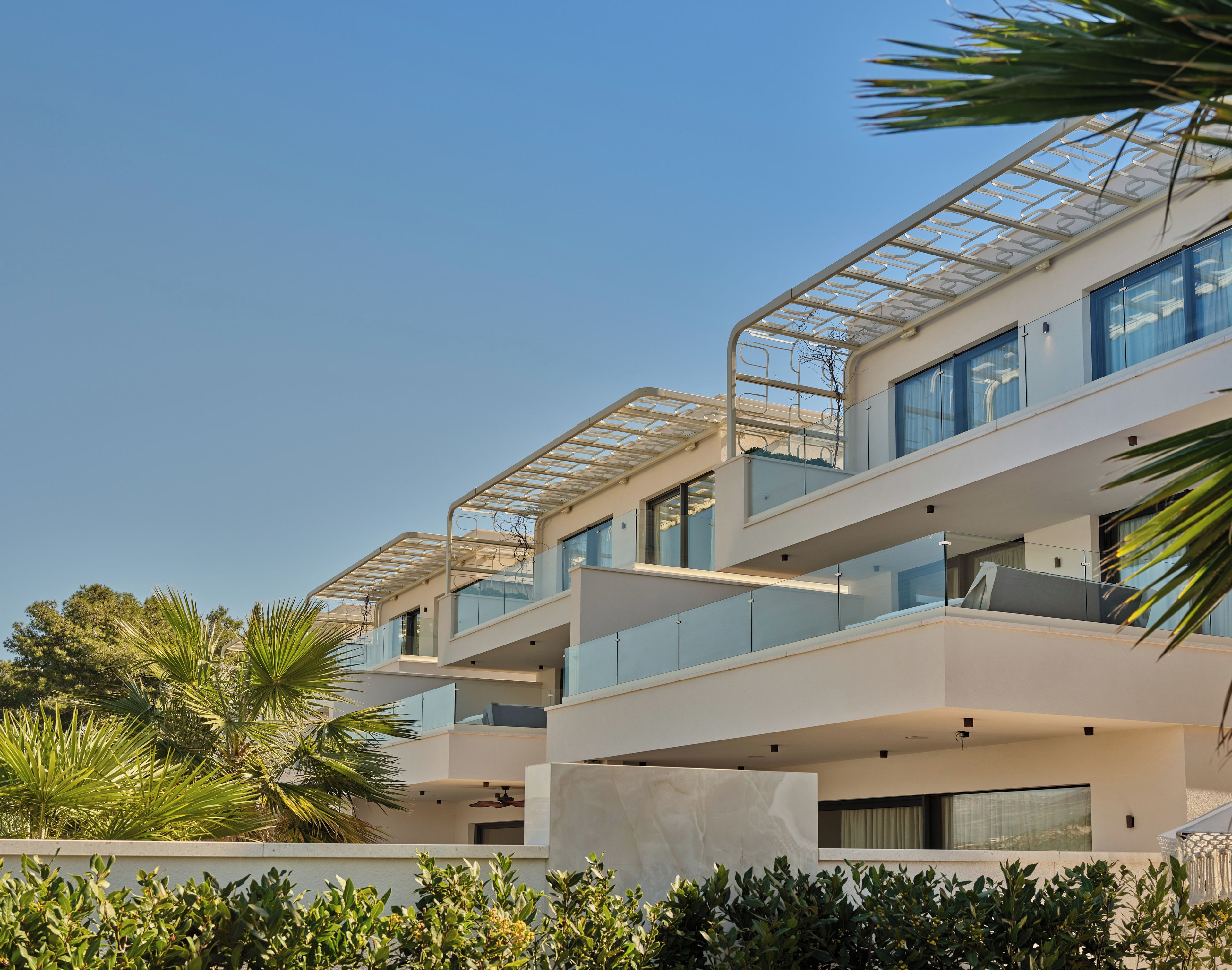A modern multi-story building with balconies and large windows.