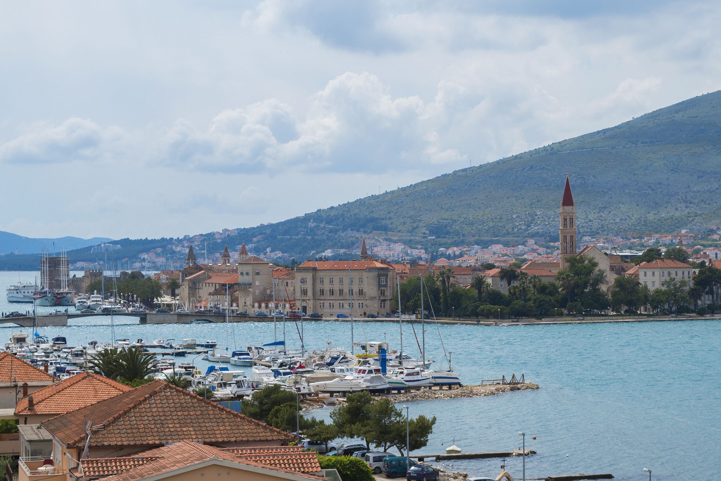 A coastal town with a marina, historic buildings, and a prominent church tower.