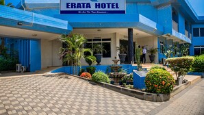 The exterior of Erata Hotel with a blue facade, a reception area, and a landscaped entrance. - Erata Hotel (Accra)