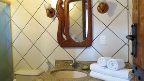 Une salle de bain équipée d’un lavabo, d’un miroir, d’une serviette et de toilettes.