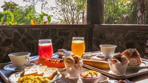 Ein Frühstückswagen mit Toast, Rührei, einem roten Getränk, Orangensaft und Gebäck.