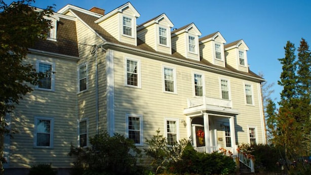 A large, two-story house with a symmetrical facade, multiple windows, and a central entrance with a porch. - DesBarres Manor Inn (Guysborough)