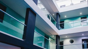 A multi-level interior with glass railings and a modern architectural design. - Hotel Flamingo (Mérida)