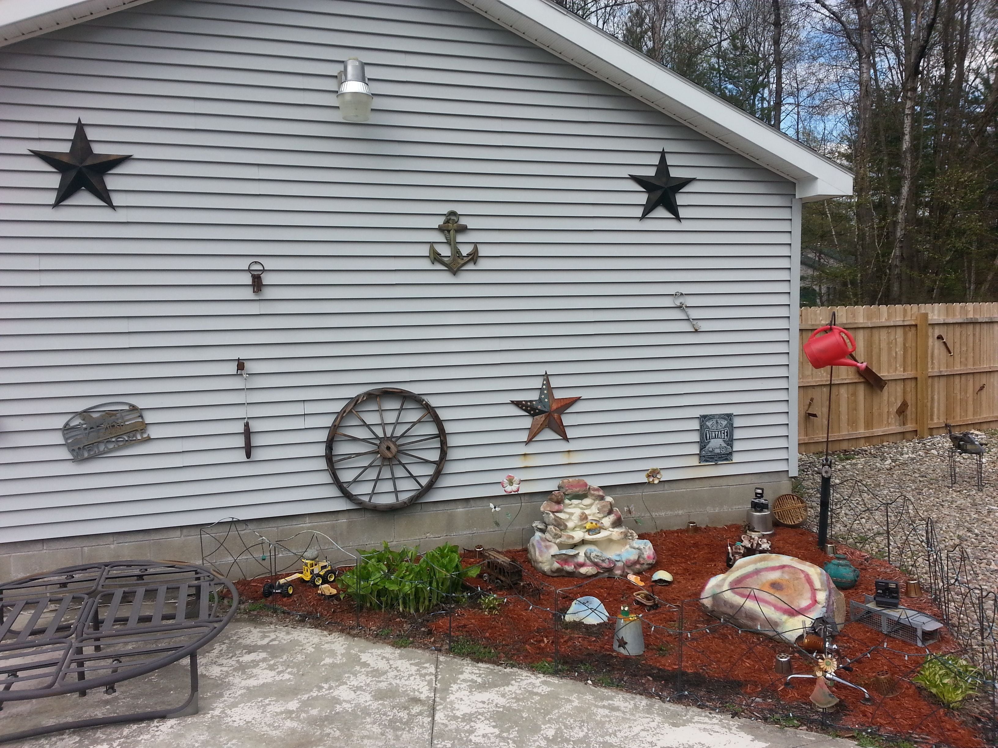 A house with a white exterior, decorated with stars, a wagon wheel, and various other items.