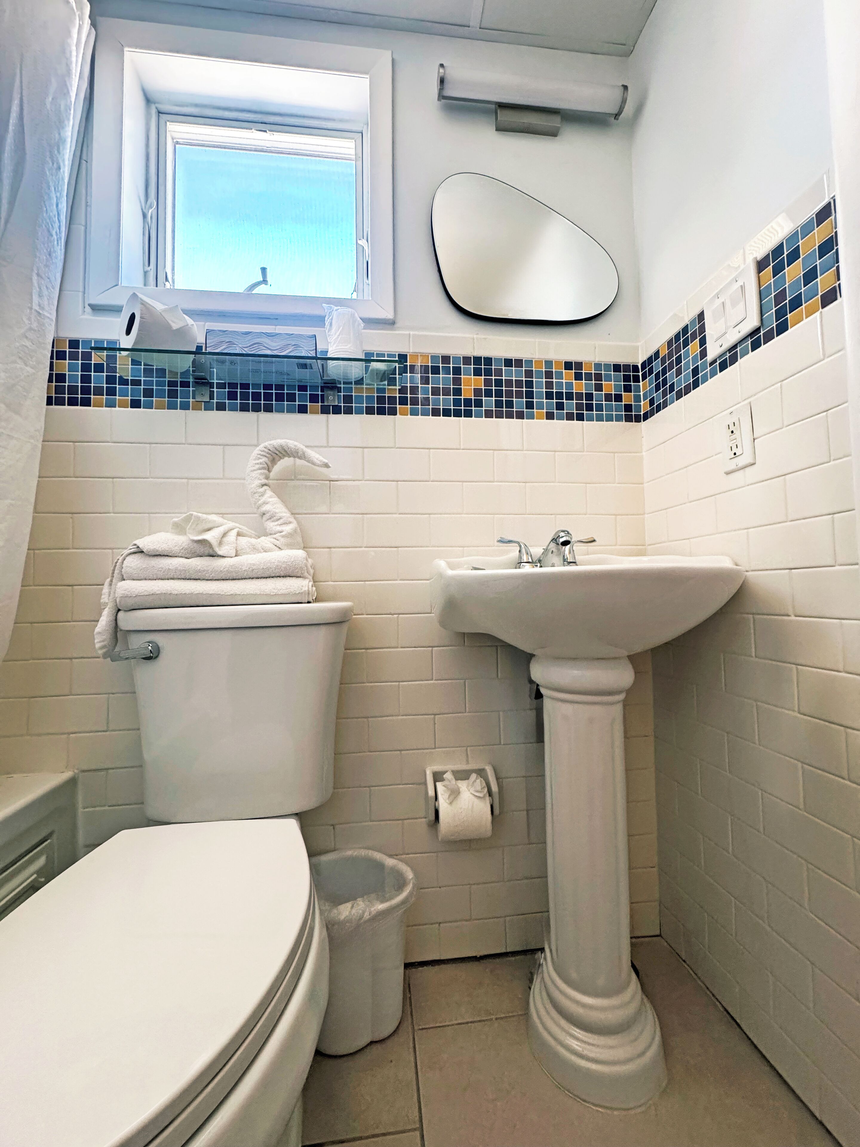 Un baño con inodoro, lavamanos y ventana.