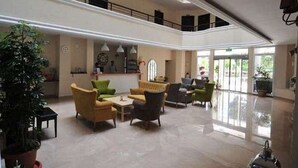 A spacious lobby with a high ceiling, comfortable seating areas, and large windows allowing natural light. - Incekum Su Hotel (Alanya)