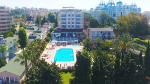 A hotel with a central swimming pool, surrounded by palm trees and other greenery. - Incekum Su Hotel (Alanya)