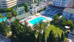 A hotel complex with multiple buildings, a central swimming pool, and surrounding greenery. - Incekum Su Hotel (Alanya)