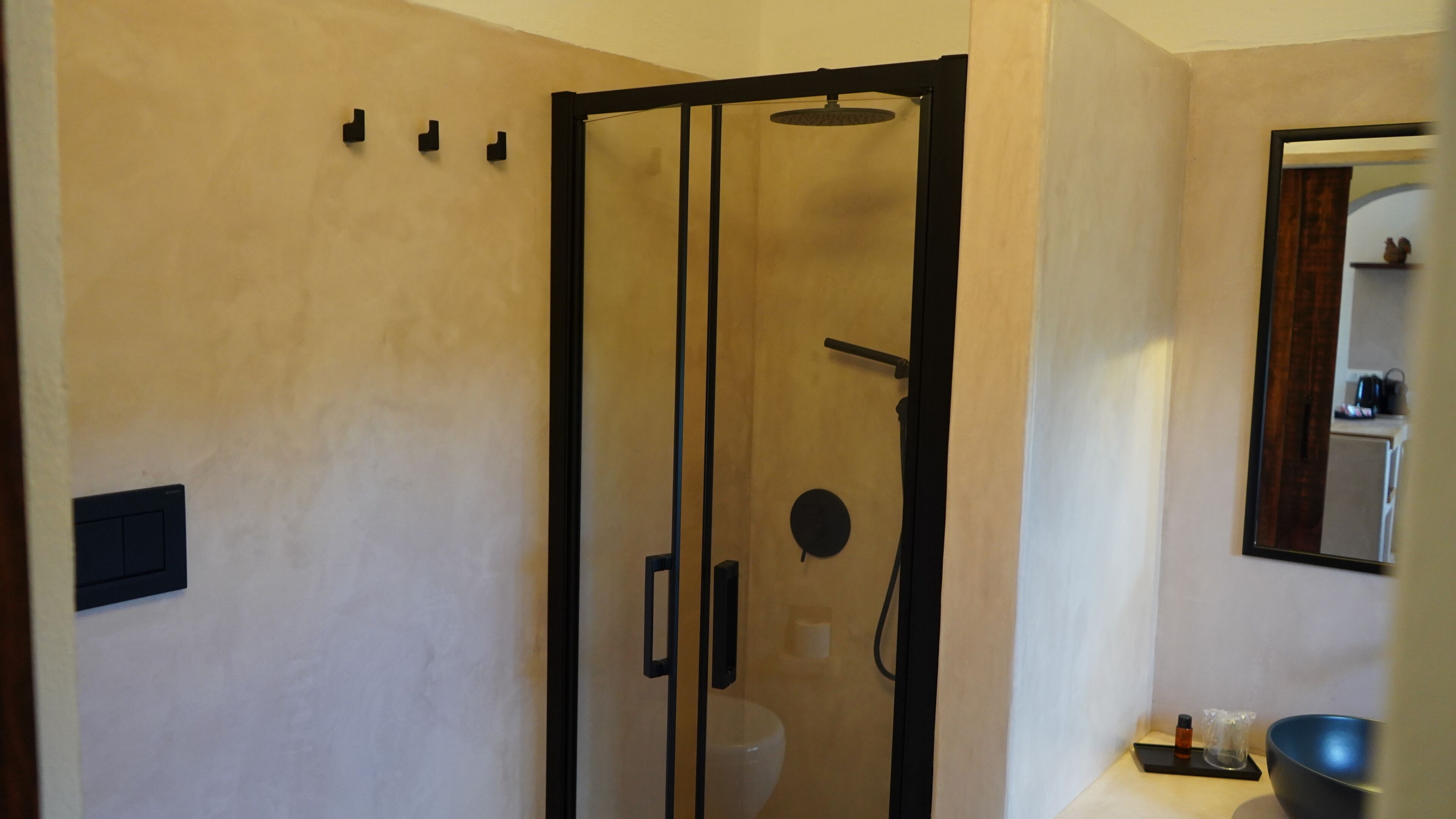 Un baño moderno con ducha de vidrio, inodoro y lavamanos.