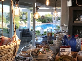 A bar area with a view of a pool and outdoor seating.