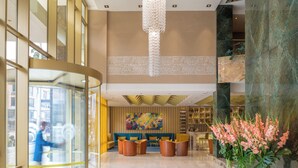 A spacious lobby with a high ceiling, a large chandelier, a bar area, and a seating area with sofas and chairs. - Hotel El Dorado Bogota (Bogotá)