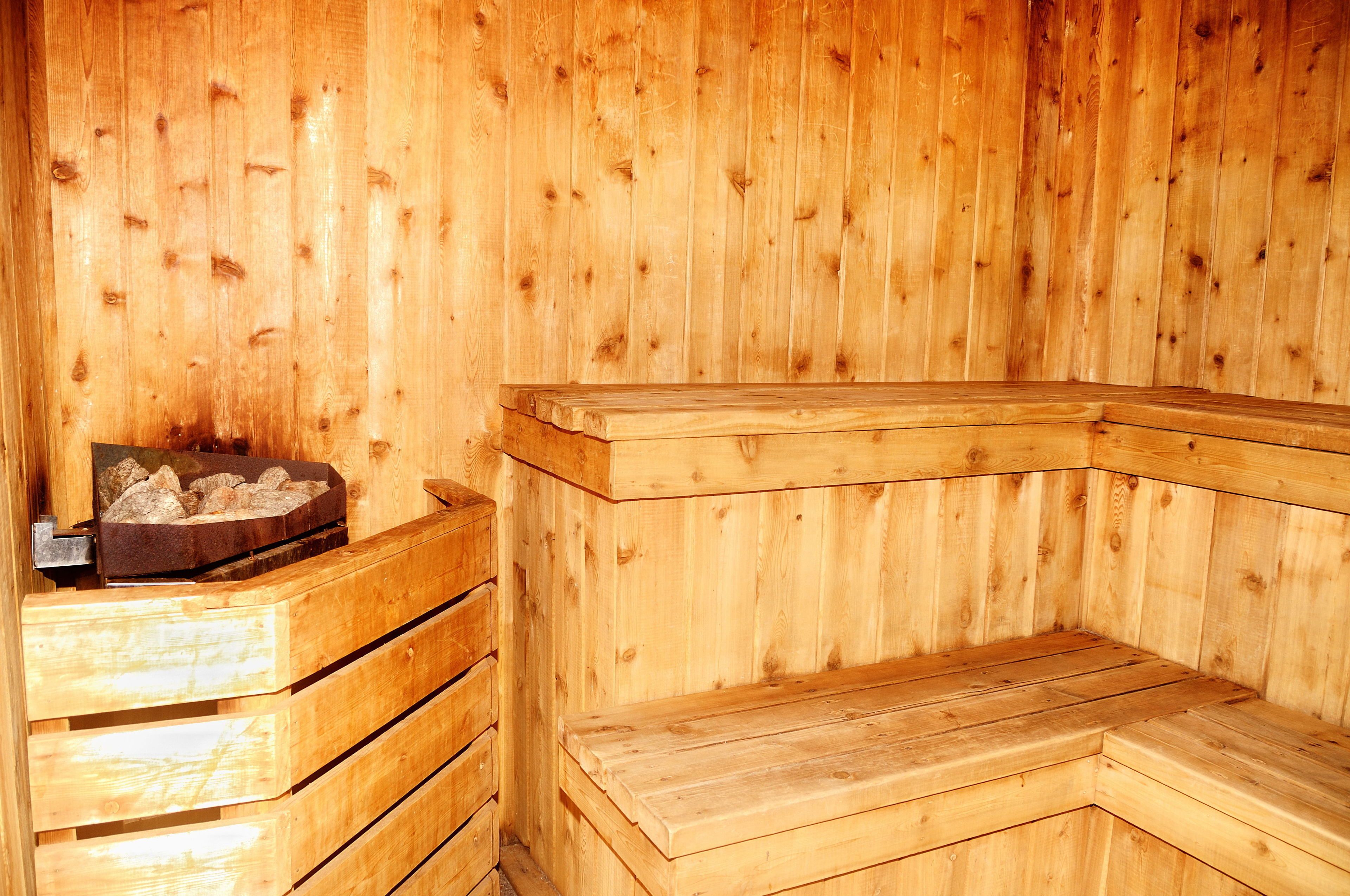 A wooden sauna with benches and a heated stone bed.
