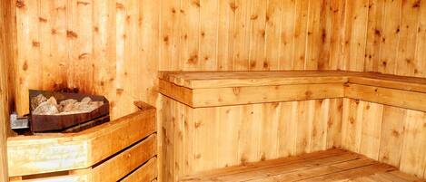 A wooden sauna with benches and a heated stone bed.