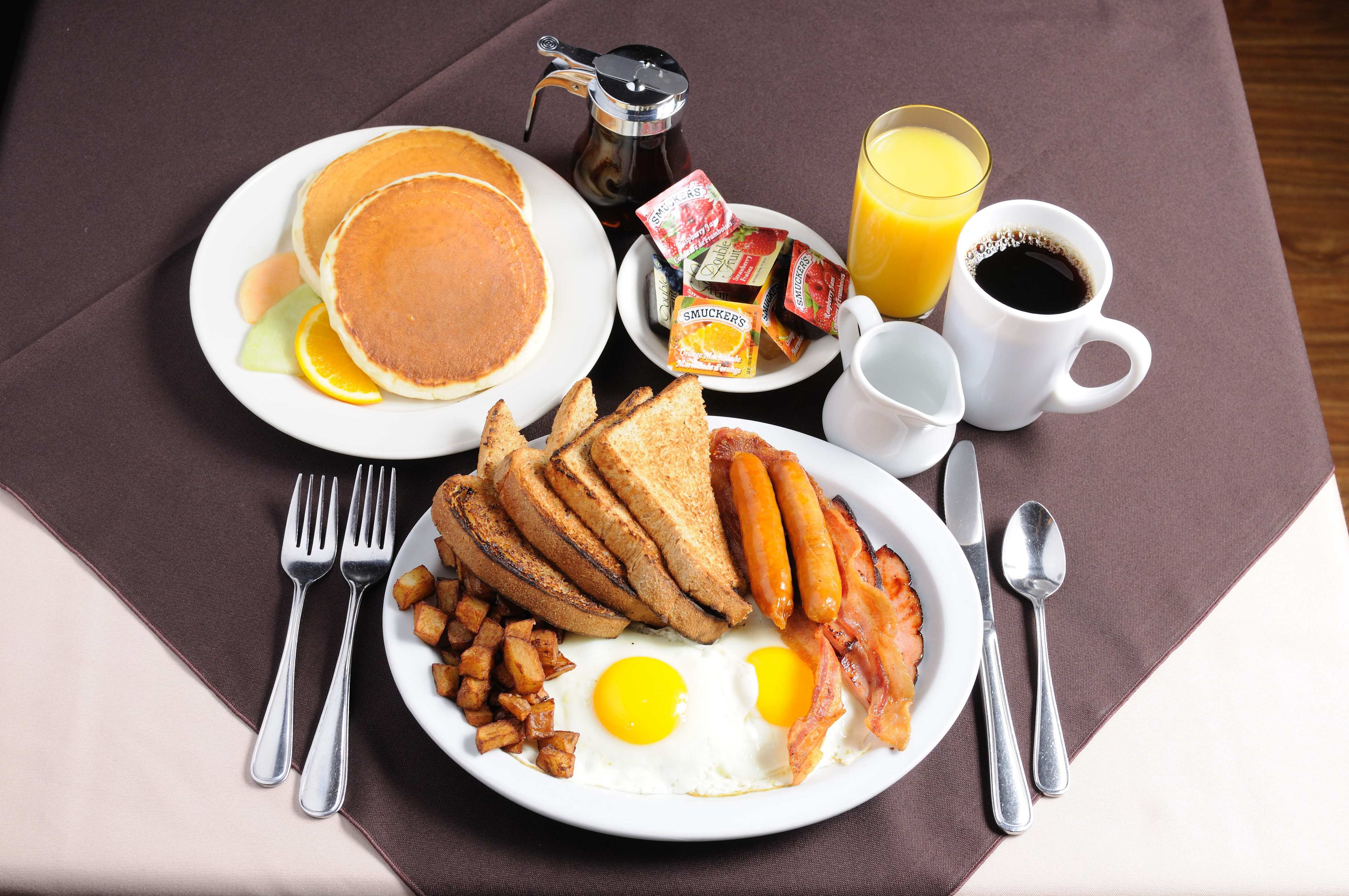 A breakfast plate with pancakes, eggs, bacon, toast, and hash browns.