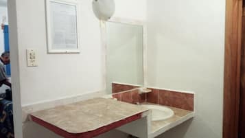 Ein Badezimmer mit Waschbecken, Spiegel und Wandseifenspender.