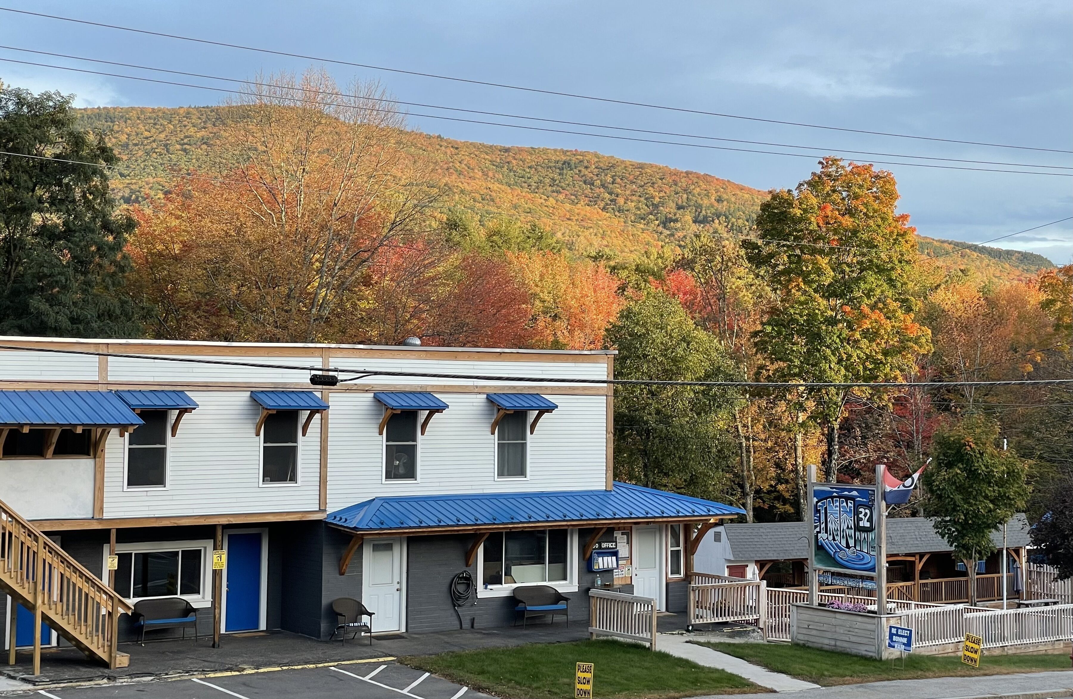 A motel with a blue roof, a front desk, and a signboard.