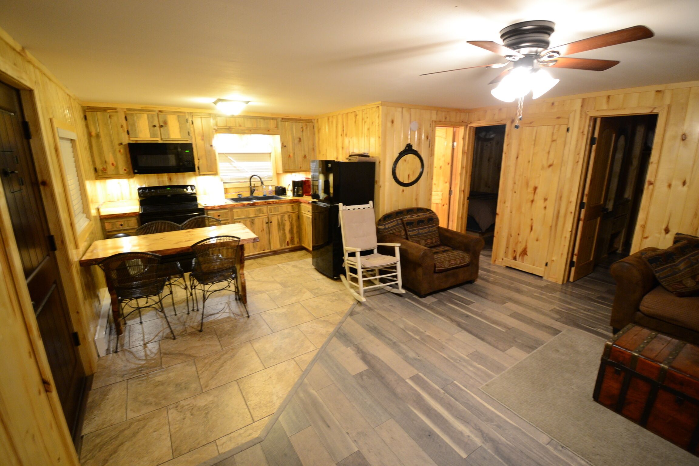 Interior de una cabaña de madera con cocina, comedor y sala de estar.