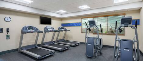 A fitness room with treadmills, elliptical machines, and a stationary bike.