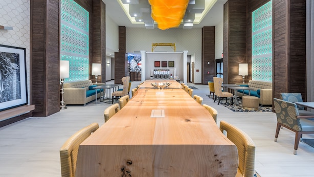 A spacious conference room with a long wooden table, comfortable seating, and decorative lighting. - Hampton Inn & Suites Dallas-The Colony, TX (The Colony)