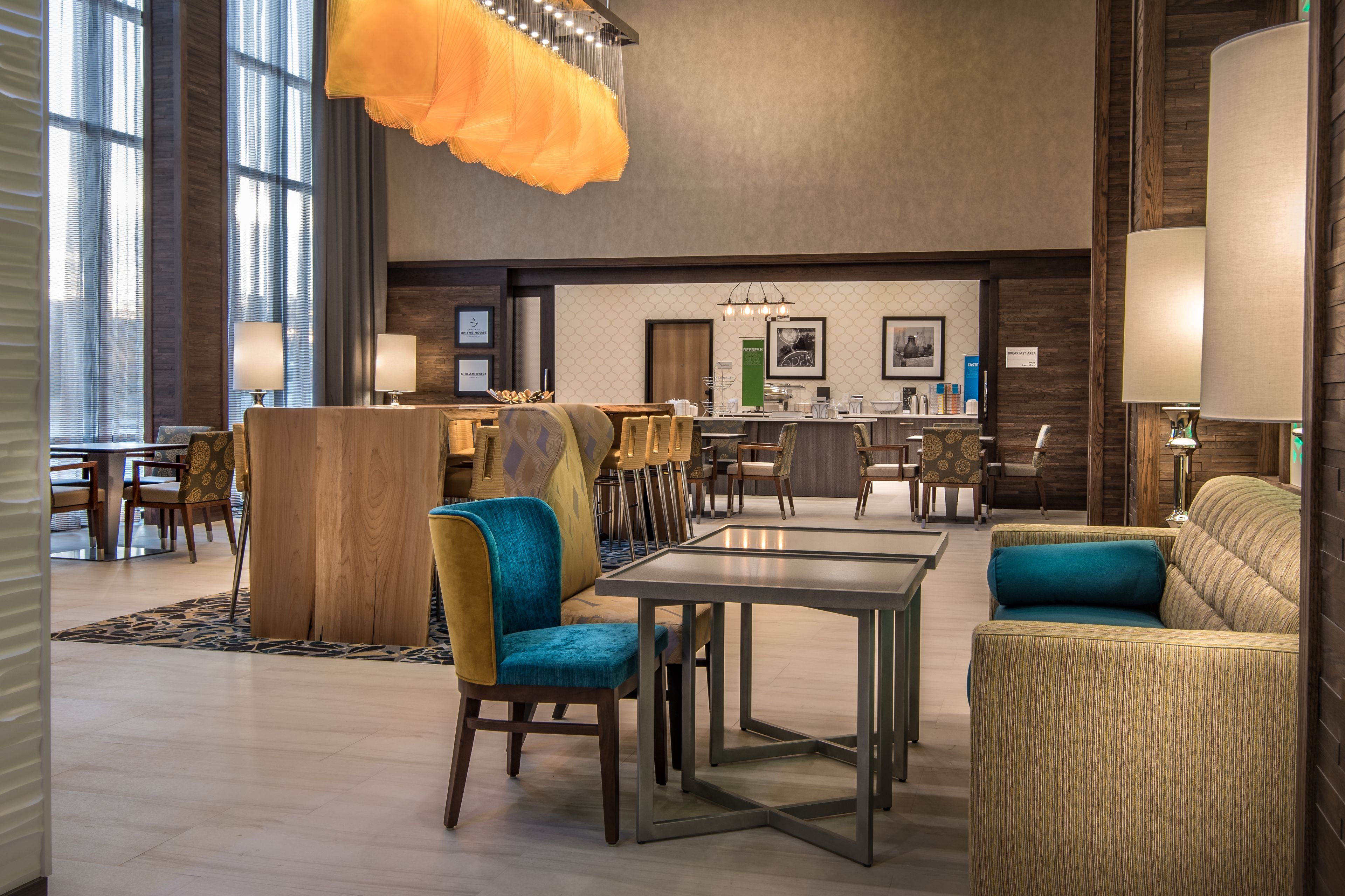 A spacious lobby with a modern bar area, comfortable seating, and large windows allowing natural light.