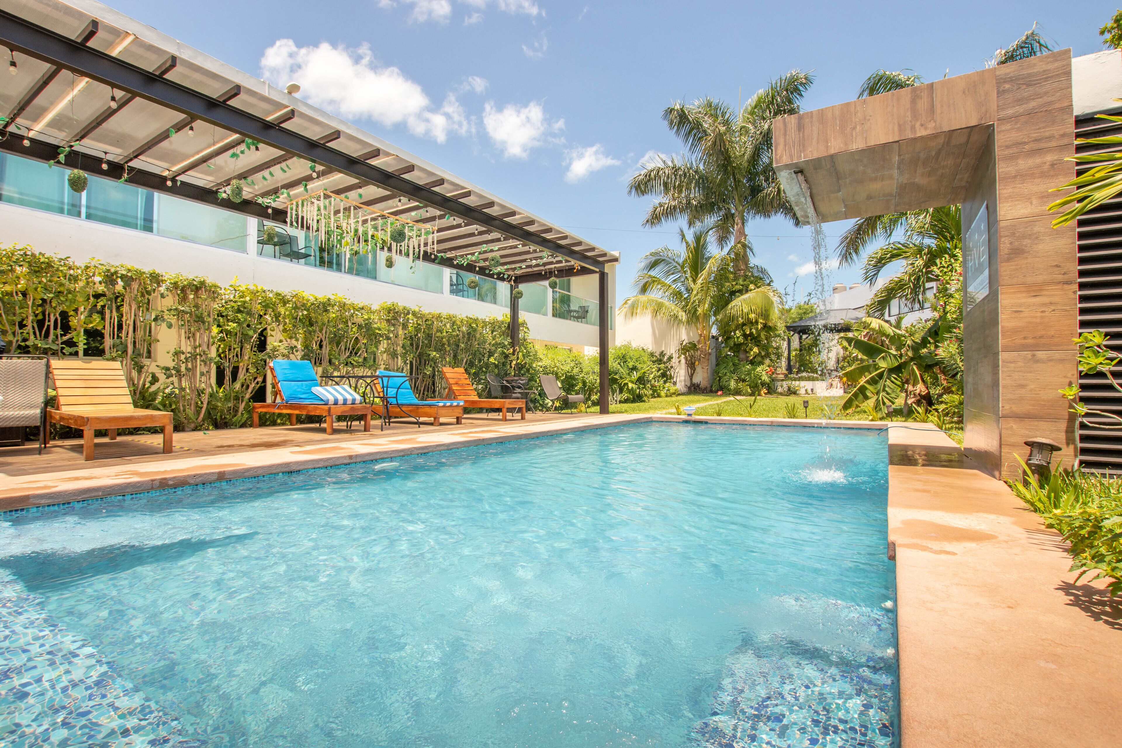 Alberca al aire libre, sombrillas en la alberca y camastros 