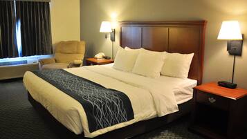 A hotel room with a bed, two bedside lamps, a chair, a nightstand with a phone, and a window with curtains.