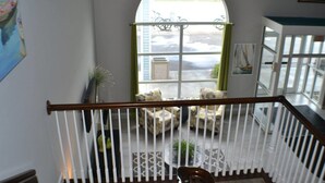 A staircase with a white railing leading to a balcony with outdoor seating. - Dunes Express Inn & Suites (Hart)
