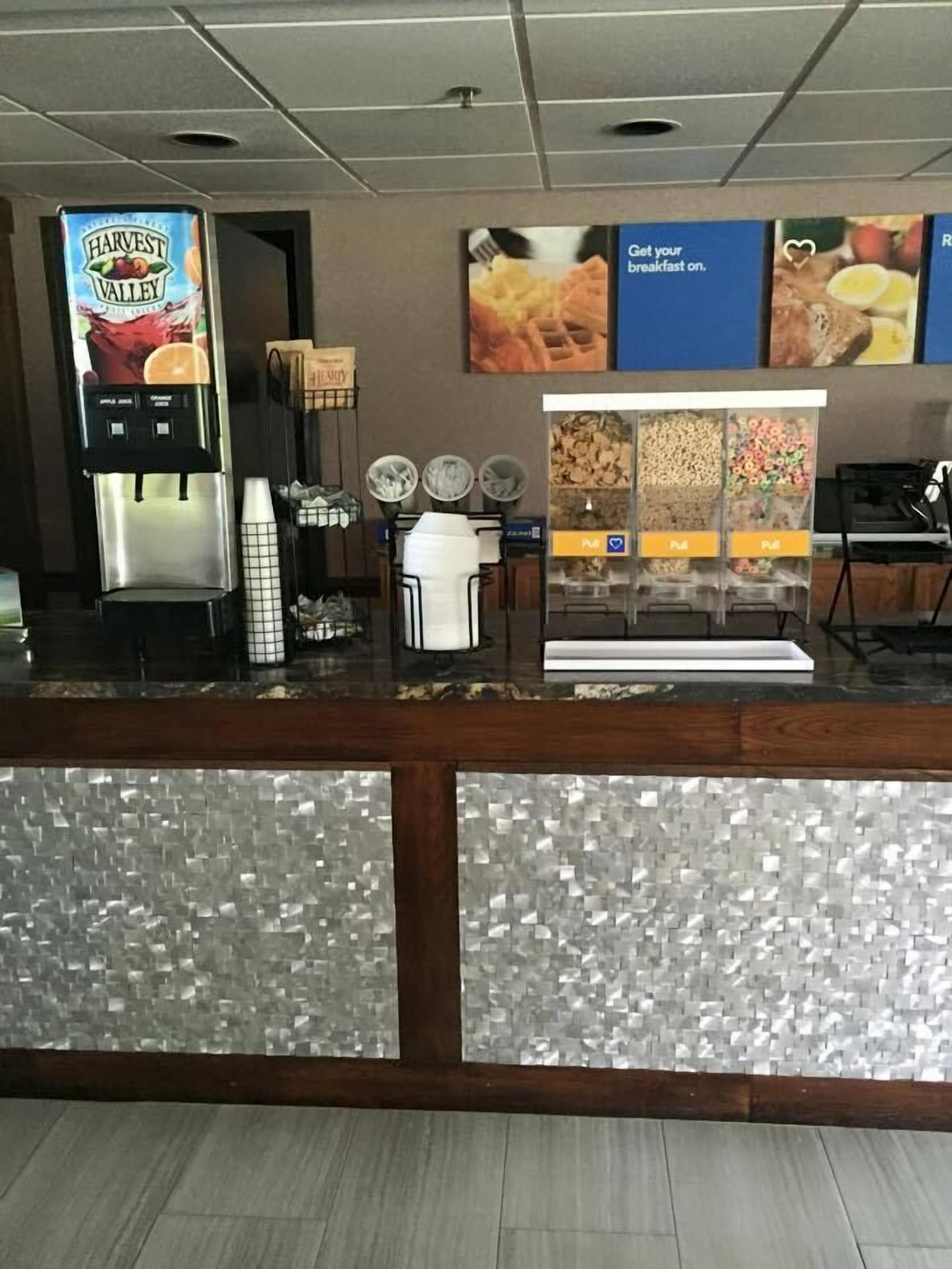 A breakfast bar with a Harvest Valley juice dispenser, a coffee machine, and a cereal dispenser.