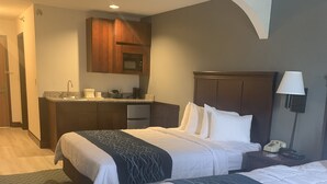 A hotel room with two beds, a kitchenette, and a bathroom. - Dunes Express Inn & Suites (Hart)