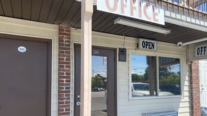 A building with a sign that reads "OFFICE" and another sign indicating "OPEN". - Redwood Inn (Gadsden)