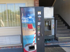 A vending machine with a beach scene, a stairway, and a door labeled 'SCOTTSBYS.' - Redwood Inn (Gadsden)
