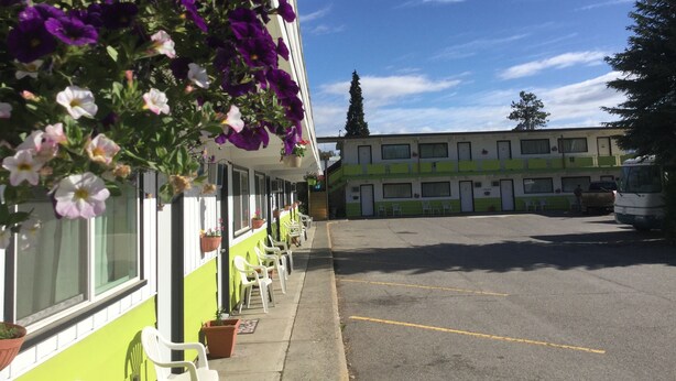 A row of single-story buildings with a parking lot in front.