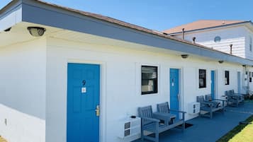 A white building with blue doors, numbered 9 and 10, and a porch with benches.