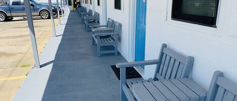 A motel corridor with rows of single-occupancy rooms, each with a window and a door.