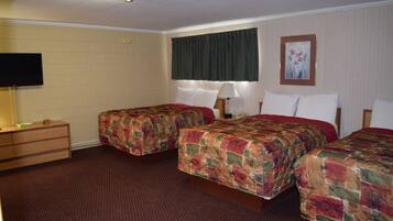 Habitación de hotel con dos camas, un televisor, un aparador y un cuadro en la pared.