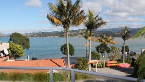 Vista costera con cielo despejado, palmeras y una masa de agua.