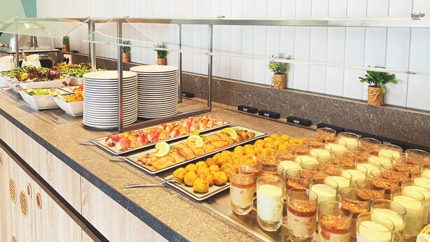Un bufé con diversas opciones de comida y bebidas.