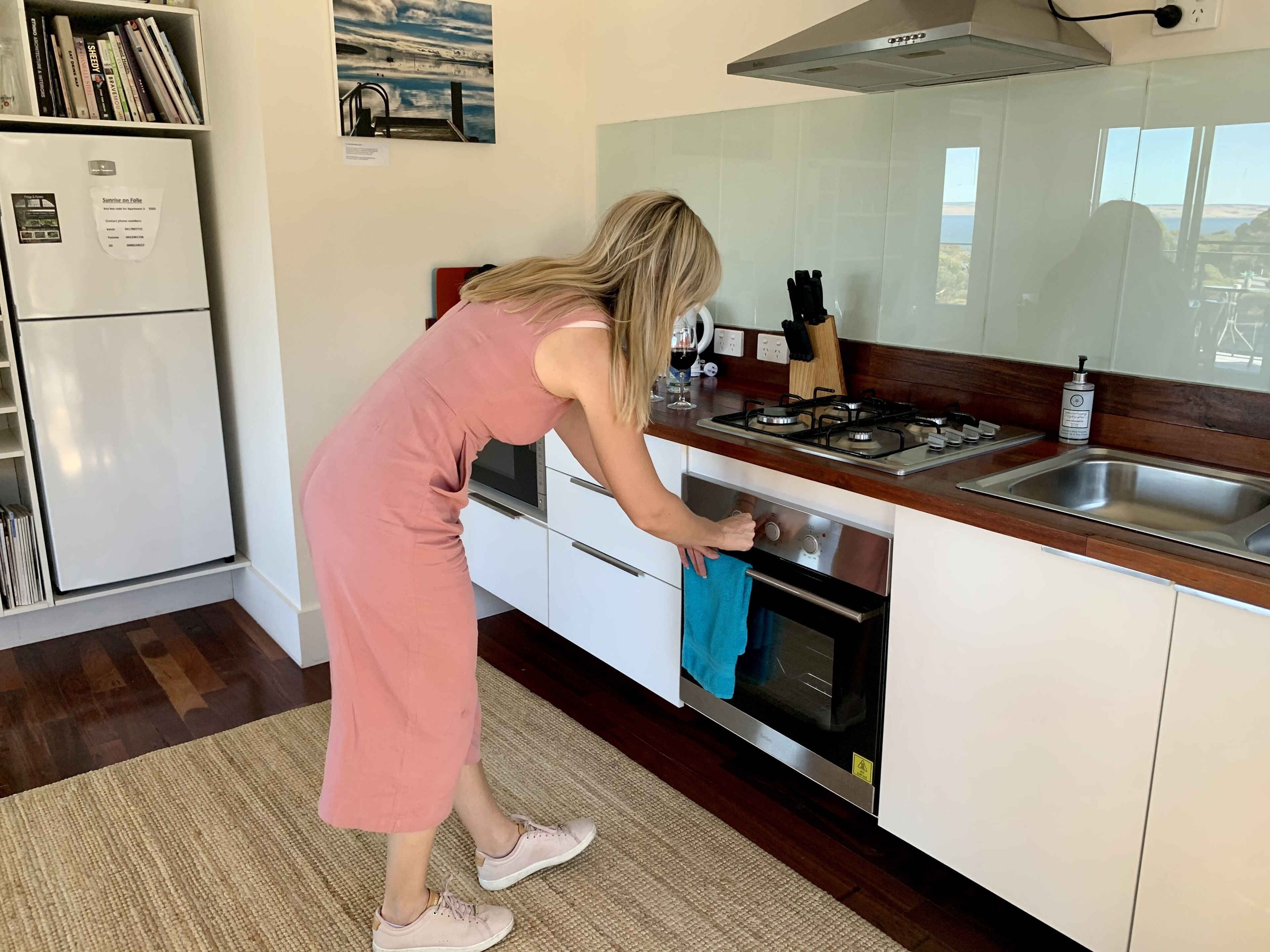 A modern kitchen with a stainless steel range hood, a built-in oven, and a sink.