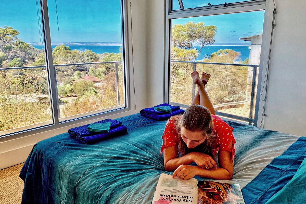 A room with a bed, a window, and a magazine.