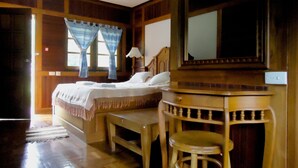 A room with a bed, a wooden desk, a chair, and a mirror. - Saksuay Klangdoi Resort (Mae Hong Son)