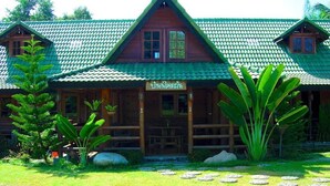 A wooden lodge with a green tiled roof, a porch, and a sign that reads "Lodge". - Saksuay Klangdoi Resort (Mae Hong Son)