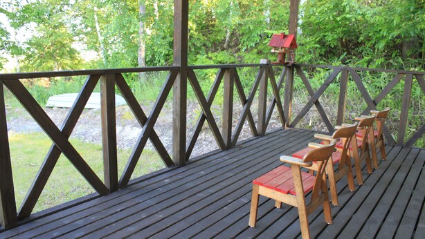 A wooden deck with a railing, benches, and a birdhouse. - Tocotoco House (Nakafurano)