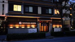 En byggnad med en skylt som visar texten "TOYOTAYA HOSTEL" och som är byggd i traditionell japansk arkitektonisk stil.